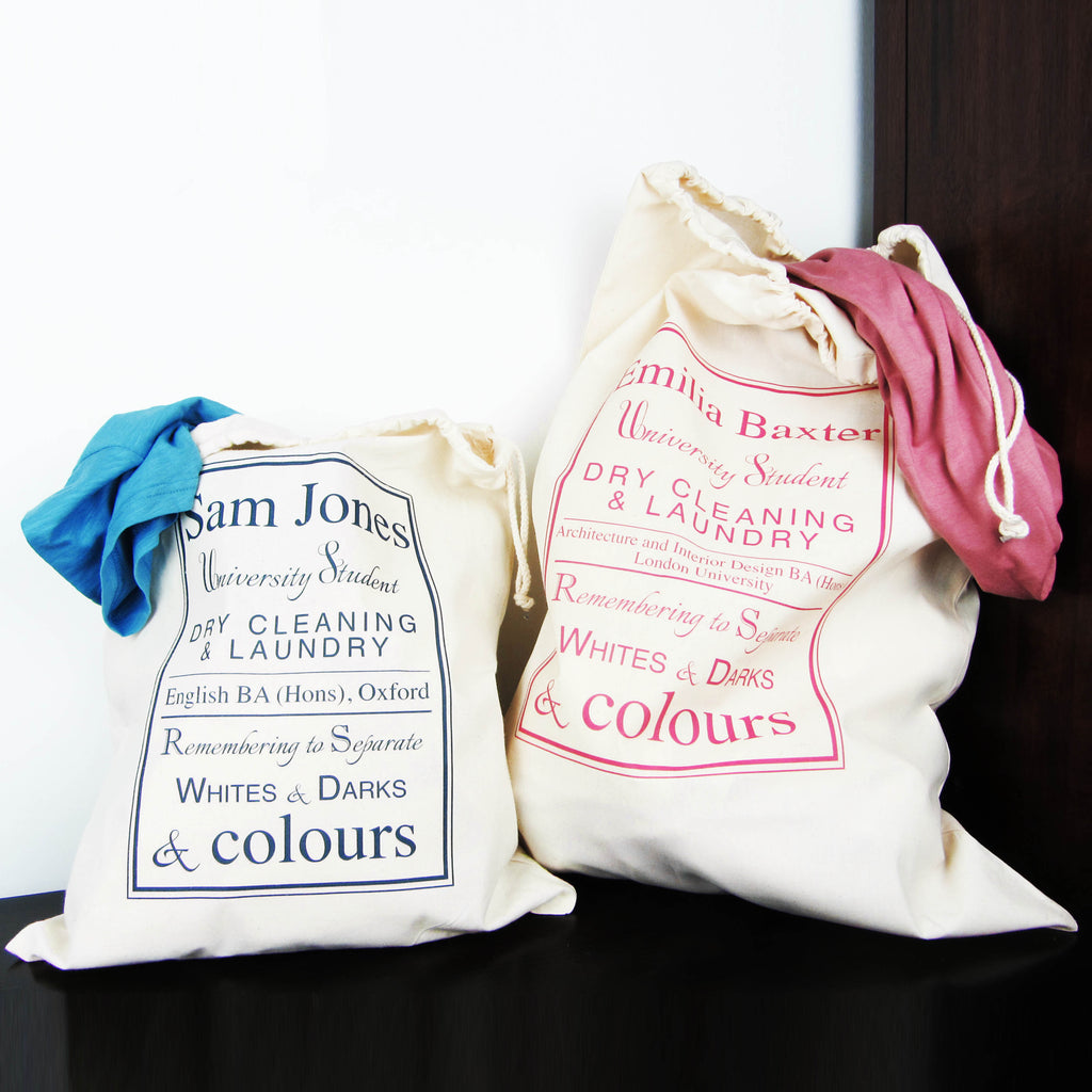 Two white bags with printed text and clothing items on a dark surface.