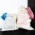 Two white bags with printed text and clothing items on a dark surface.
